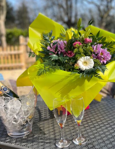 Champagne on ice with a hand-tied bouquet of flowers